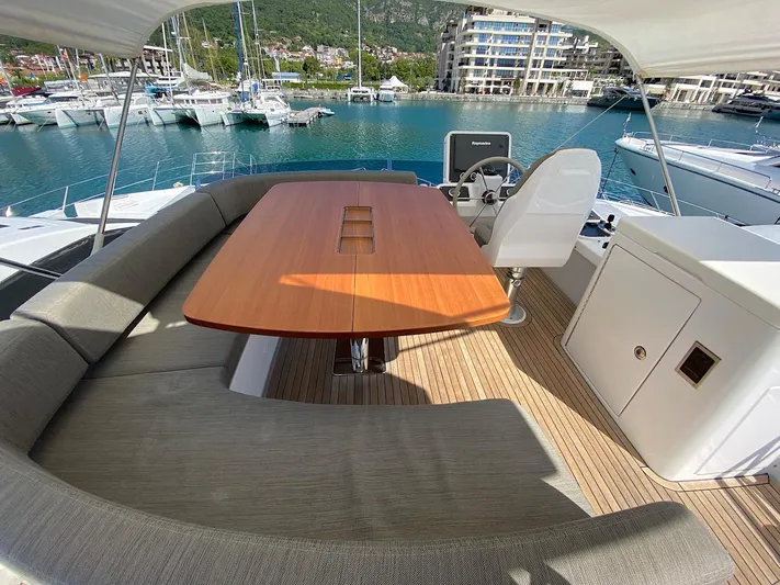 Mizar Yacht Photos Pics Azimut Magellano 53 yacht deck with seating and table, docked in a marina, 2017 model.