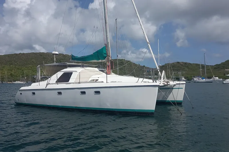 Yellowrock Yacht Photos Pics 1996 Alliaura Privilege 37 catamaran anchored in scenic bay with hills and cloudy sky.