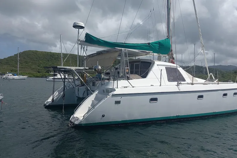 Yellowrock Yacht Photos Pics 1996 Alliaura Privilege 37 catamaran anchored in a scenic bay with lush hills.