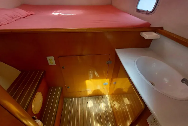 Yellowrock Yacht Photos Pics Interior of 1996 Alliaura Privilege 37 catamaran with bed, sink, and wooden flooring.