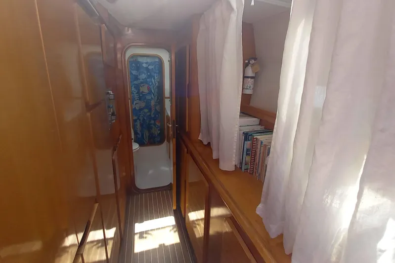 Yellowrock Yacht Photos Pics Narrow hallway inside 1996 Alliaura Privilege 37 yacht with wooden cabinets and white curtains.