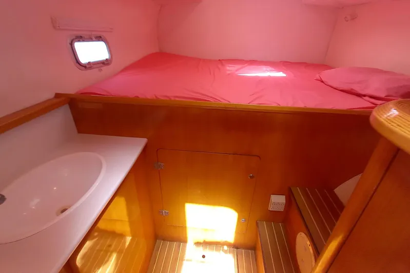 Yellowrock Yacht Photos Pics Cozy cabin interior of 1996 Alliaura Privilege 37 catamaran with pink bedding and wooden finish.