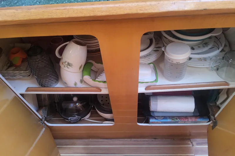 Yellowrock Yacht Photos Pics Cabinet interior on 1996 Alliaura Privilege 37, featuring dishes and kitchenware neatly organized.
