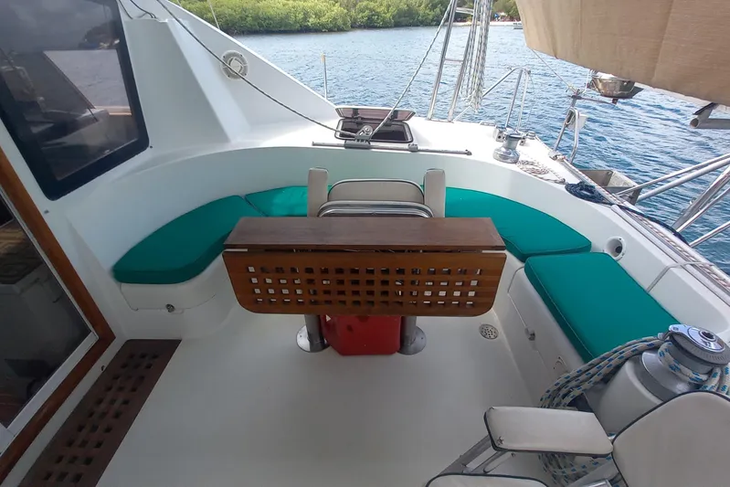 Yellowrock Yacht Photos Pics 1996 Alliaura Privilege 37 yacht cockpit with teal cushions and wooden table, docked by water.
