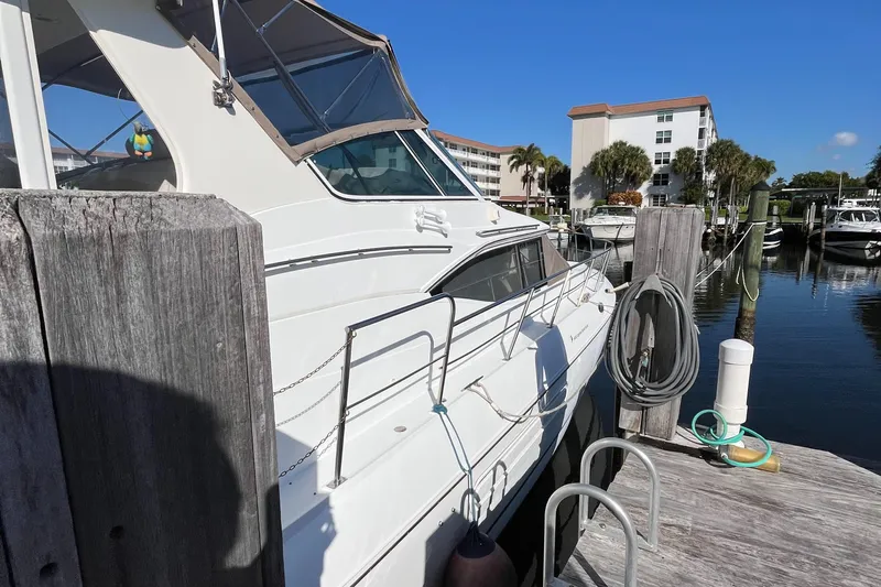 Two Can Do It II Yacht Photos Pics 2000 Cruisers Yachts 4450 Motor Yacht docked at marina under clear blue sky.