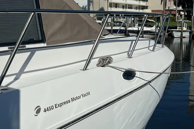 Two Can Do It II Yacht Photos Pics 2000 Cruisers Yachts 4450 Motor Yacht docked, showcasing sleek design and polished railing.