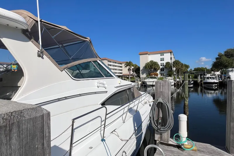Two Can Do It II Yacht Photos Pics 2000 Cruisers Yachts 4450 Motor Yacht docked at marina under clear blue sky.