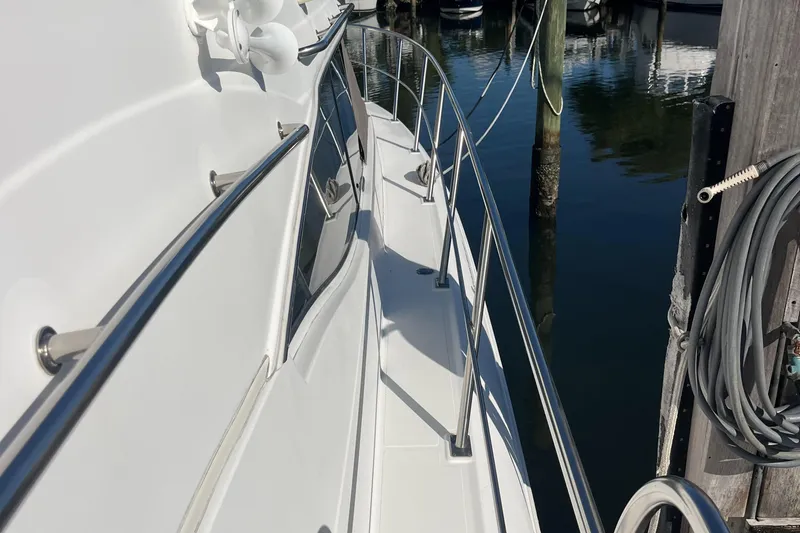 Two Can Do It II Yacht Photos Pics 2000 Cruisers Yachts 4450 Motor Yacht docked, showing sleek side deck and railing.