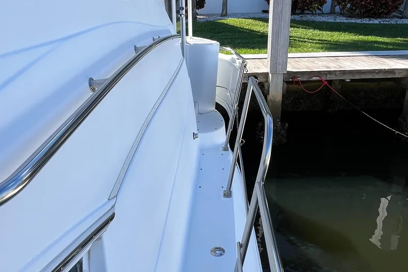 Two Can Do It II Yacht Photos Pics 2000 Cruisers Yachts 4450 Motor Yacht docked, showing sleek side railings and walkway.