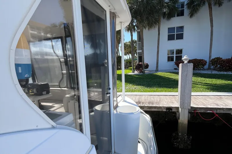 Two Can Do It II Yacht Photos Pics 2000 Cruisers Yachts 4450 Motor Yacht docked near a waterfront property.