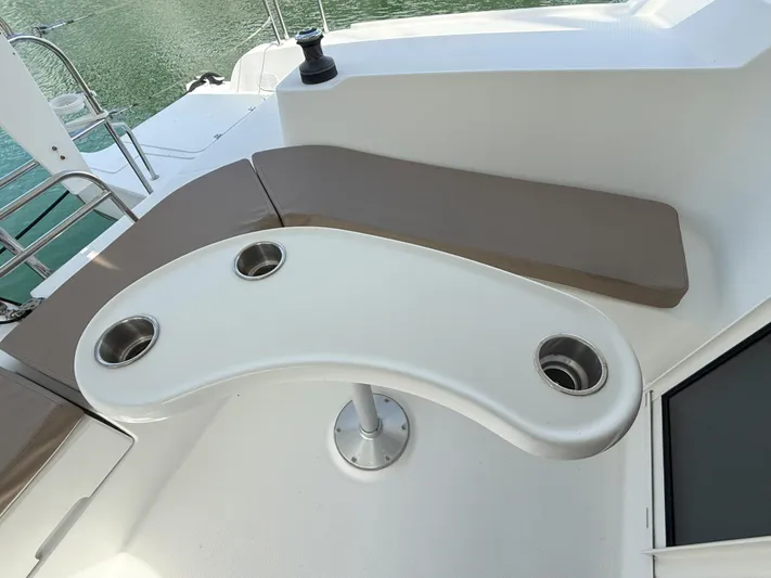 Brake Aweigh Yacht Photos Pics 2014 Fountaine Pajot Mahe 36 Evolution yacht seating area with curved table and cup holders.