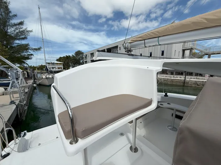 Brake Aweigh Yacht Photos Pics 2014 Fountaine Pajot Mahe 36 Evolution yacht helm station with cushioned seat, docked at marina.