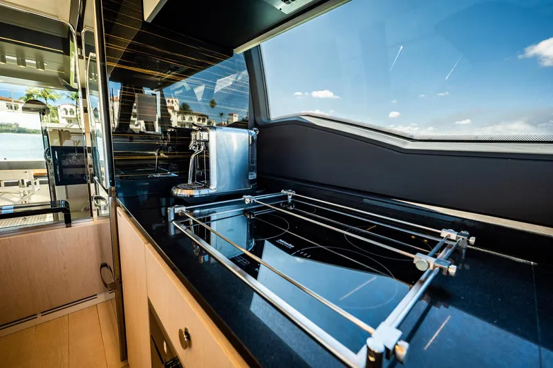 Amici Yacht Photos Pics Luxurious kitchen interior of 2017 Azimut 66 yacht with sleek black countertops.