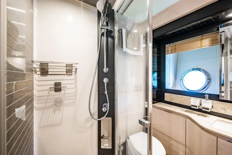 Amici Yacht Photos Pics Luxurious bathroom in 2017 Azimut 66 yacht with modern shower and porthole window.