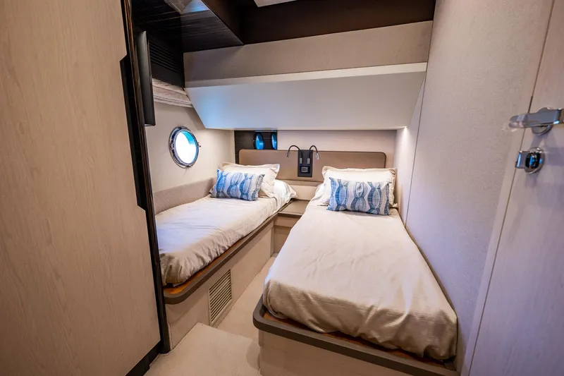 Amici Yacht Photos Pics Twin cabin interior of 2017 Azimut 66 yacht with modern decor and porthole window.
