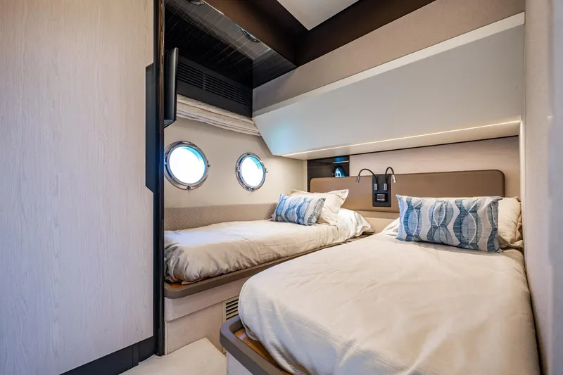 Amici Yacht Photos Pics Luxurious cabin interior of 2017 Azimut 66 yacht with twin beds and porthole windows.