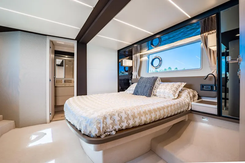 Amici Yacht Photos Pics Luxurious bedroom interior of 2017 Azimut 66 yacht with elegant decor and large window.