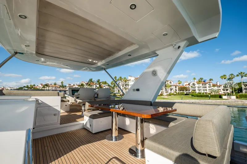 Amici Yacht Photos Pics Luxurious 2017 Azimut 66 yacht deck with seating and table, overlooking waterfront homes.