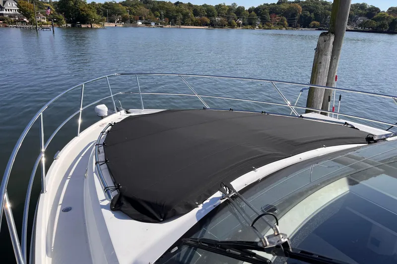  Yacht Photos Pics 2024 Galeon 425 HTS yacht bow with black cover, docked by serene waters.