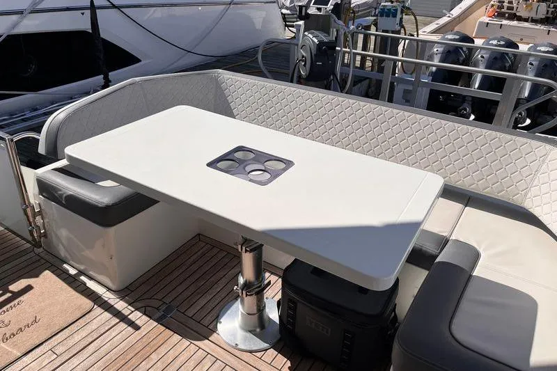  Yacht Photos Pics Luxury seating area on 2024 Galeon 425 HTS yacht with elegant table and cushioned benches.
