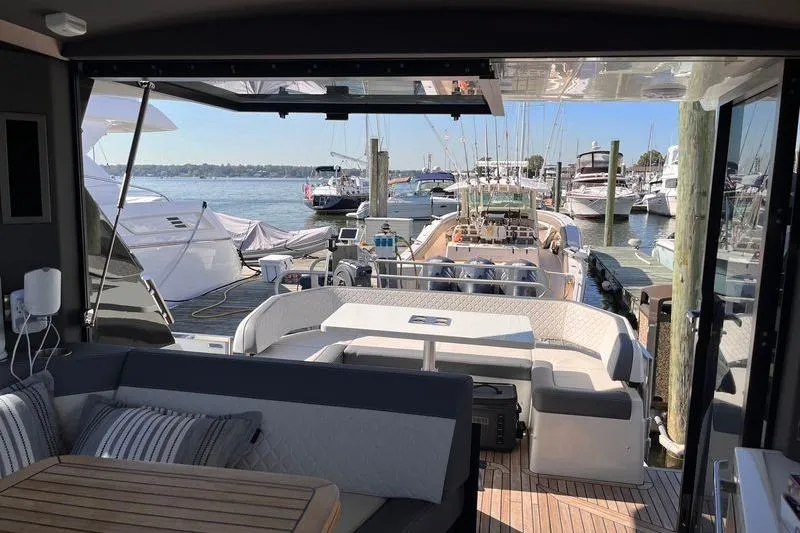  Yacht Photos Pics 2024 Galeon 425 HTS yacht interior with marina view, featuring elegant seating and table.