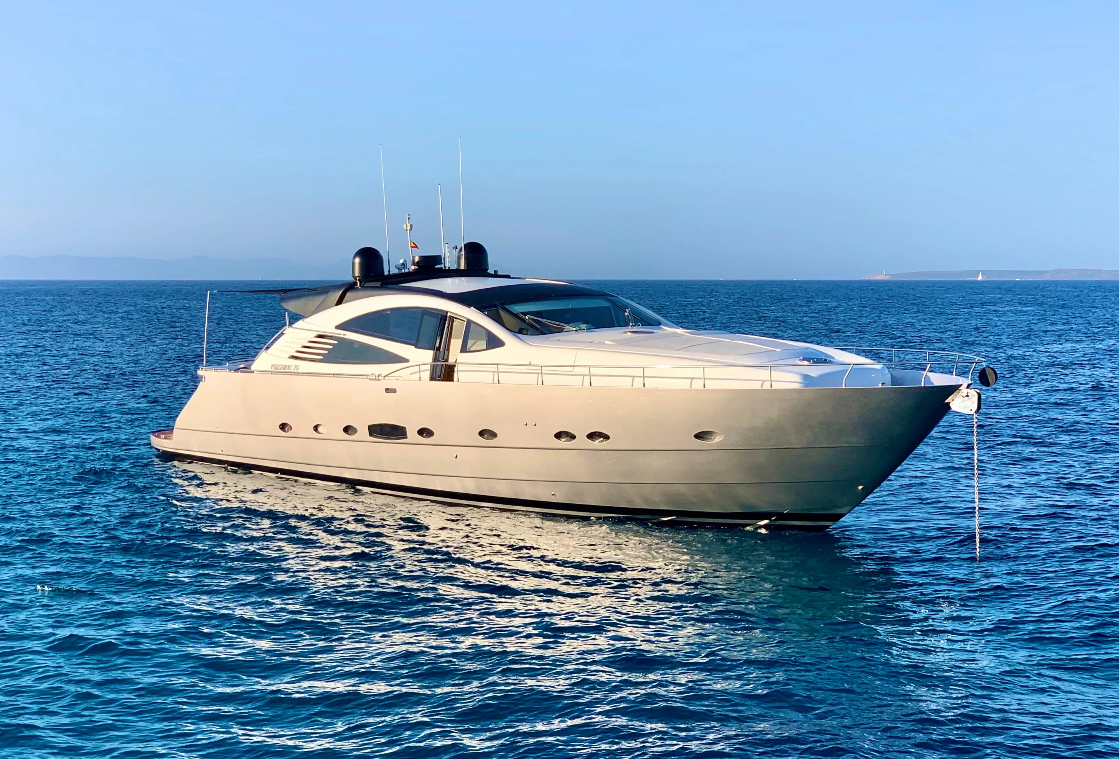 Luxury 2005 Pershing 76 yacht on calm blue sea under clear sky.