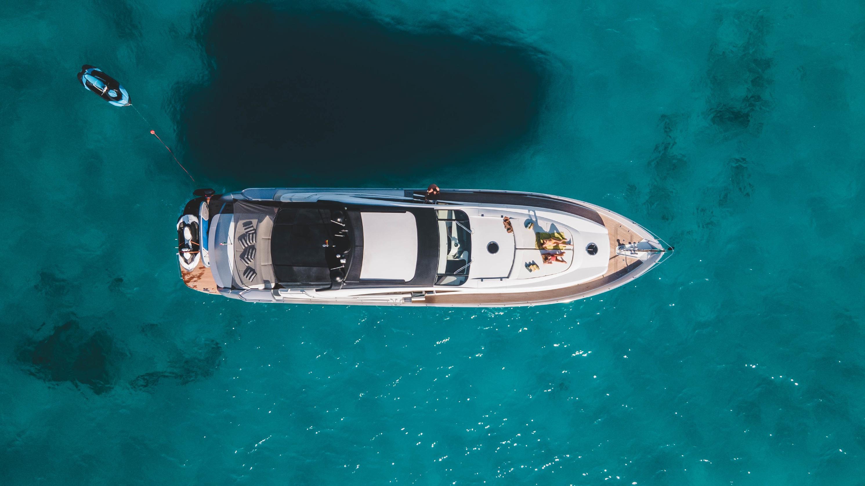 Aerial view of 2005 Pershing 76 yacht on clear turquoise water.