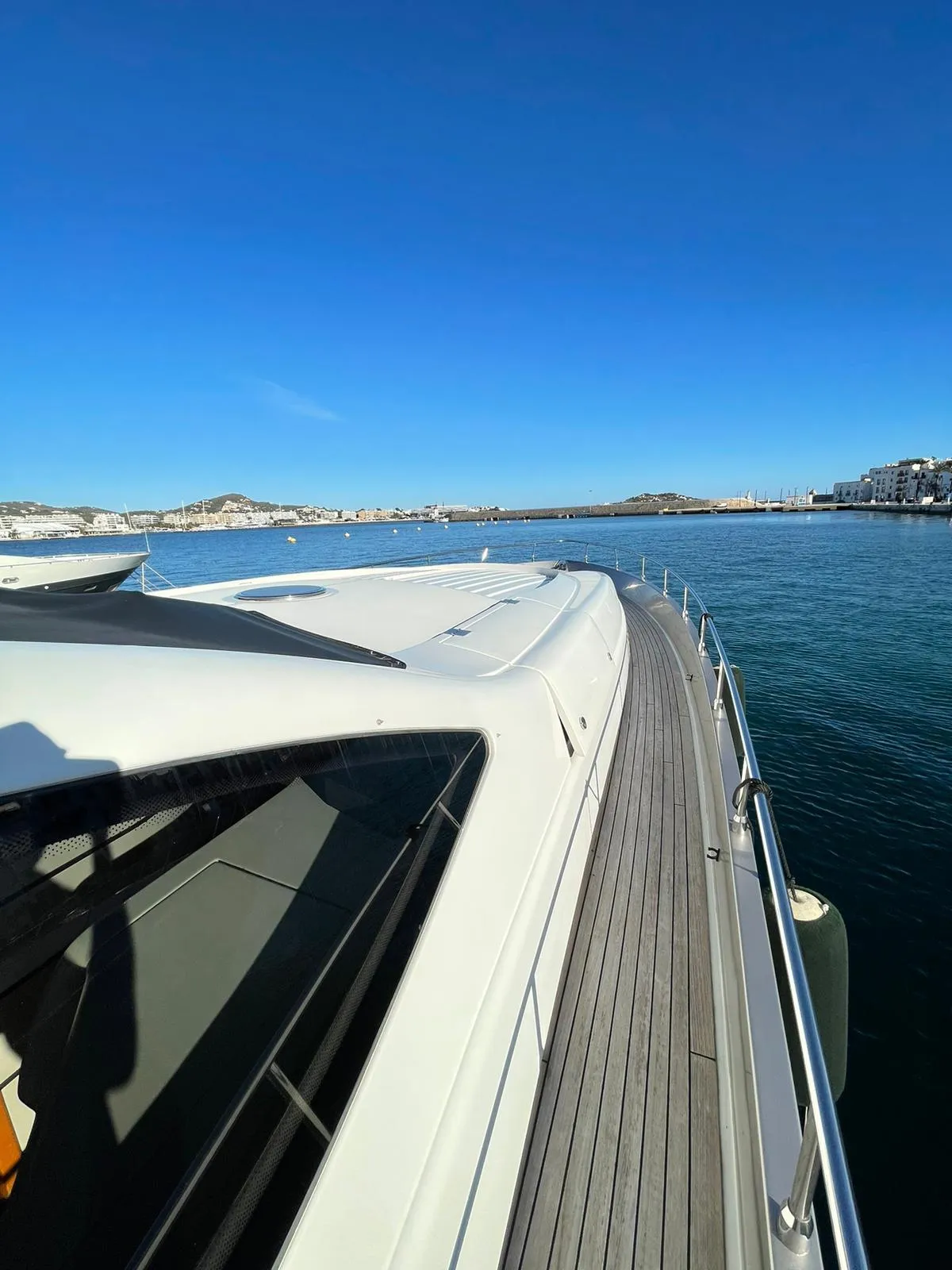 2005 Pershing 76 yacht on calm water under clear blue sky.