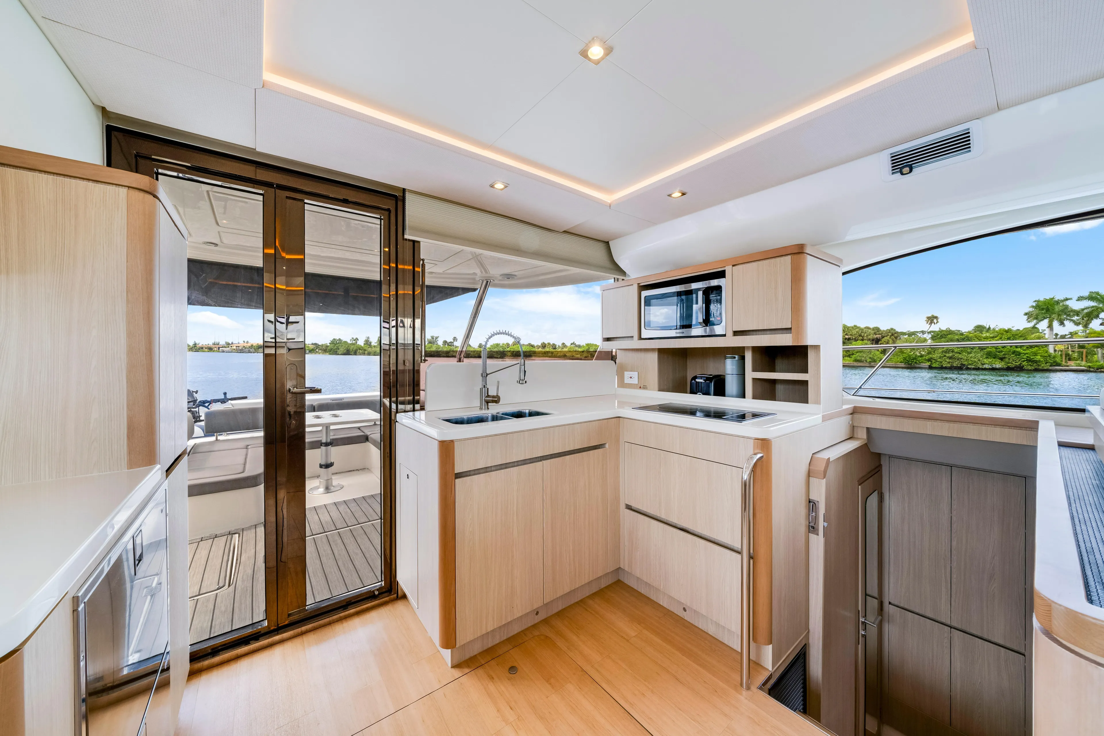 Luxurious interior of 2019 Aquila 44 Yacht with modern kitchen and scenic water view.
