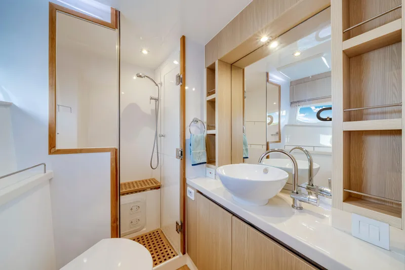 Altair Yacht Photos Pics Luxurious bathroom interior of 2019 Aquila 44 Yacht with modern fixtures and wooden accents.