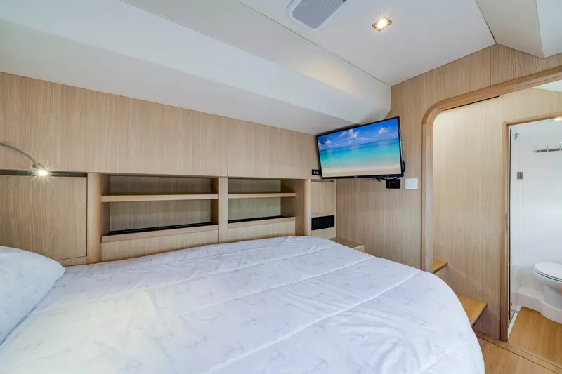 Altair Yacht Photos Pics Luxurious bedroom interior of 2019 Aquila 44 Yacht with TV and ensuite bathroom.