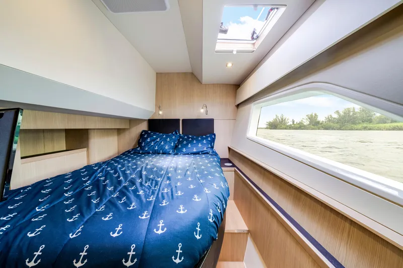 Altair Yacht Photos Pics Luxurious cabin interior of 2019 Aquila 44 Yacht with nautical-themed bedding and scenic window view.