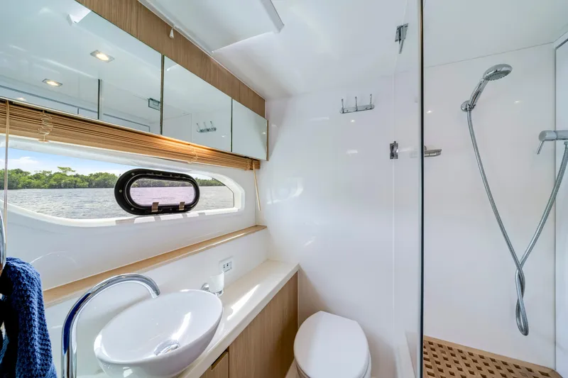 Altair Yacht Photos Pics Luxurious bathroom on 2019 Aquila 44 Yacht with modern fixtures and scenic window view.