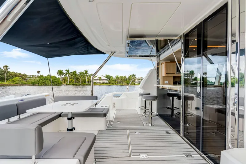 Altair Yacht Photos Pics Luxurious 2019 Aquila 44 Yacht deck with seating, bar stools, and scenic water view.