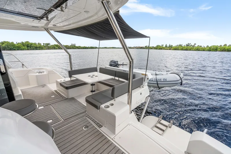 Altair Yacht Photos Pics 2019 Aquila 44 Yacht deck with seating, table, and scenic water view.