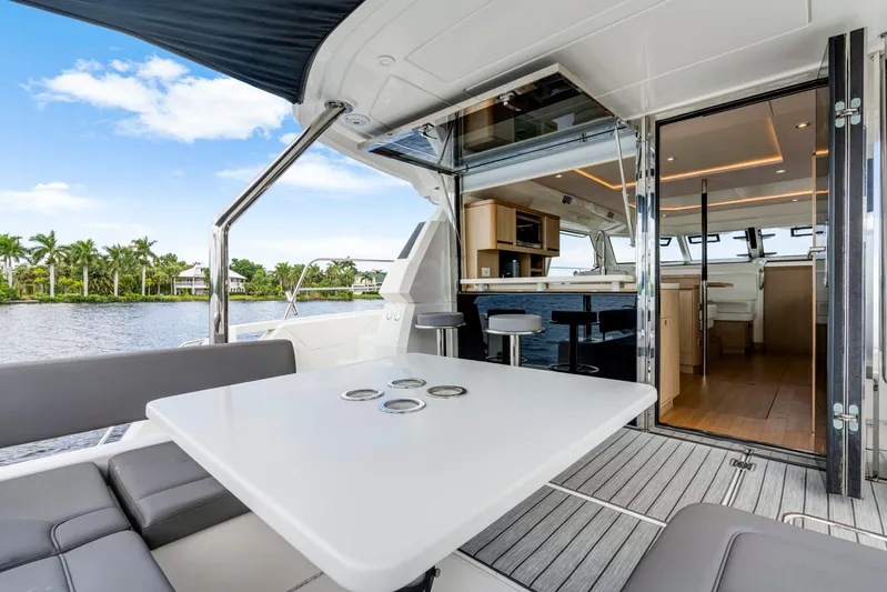 Altair Yacht Photos Pics Luxurious 2019 Aquila 44 Yacht interior with modern seating and dining area, overlooking serene waters.