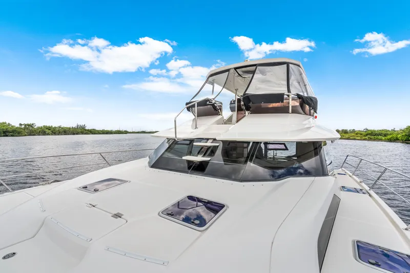 Altair Yacht Photos Pics 2019 Aquila 44 Yacht on serene water under clear blue sky.