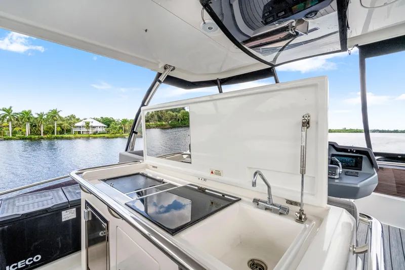 Altair Yacht Photos Pics 2019 Aquila 44 Yacht kitchen area with sink and stove, overlooking serene waterway.