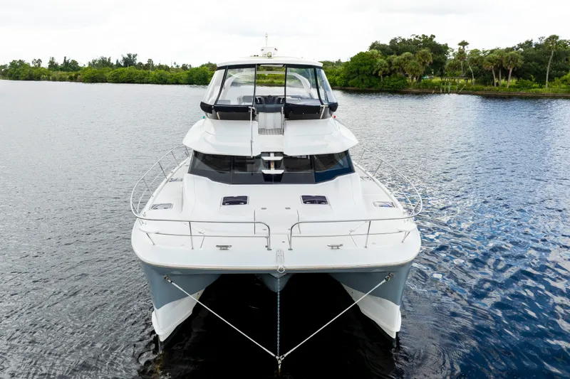 Altair Yacht Photos Pics 2019 Aquila 44 Yacht on calm water, front view with lush greenery background.