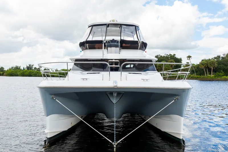 Altair Yacht Photos Pics Front view of 2019 Aquila 44 Yacht on calm water under cloudy sky.