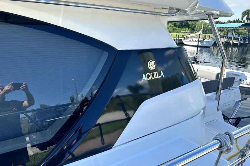 Altair Yacht Photos Pics 2019 Aquila 44 Yacht docked, showcasing sleek design and logo.
