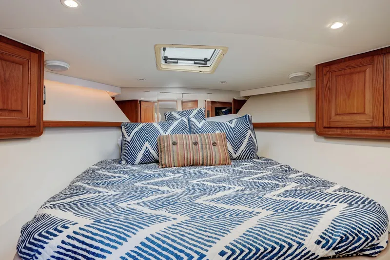 Archangel Yacht Photos Pics Cozy cabin interior of 1992 Viking 43 Open yacht with patterned bedding and wooden cabinets.