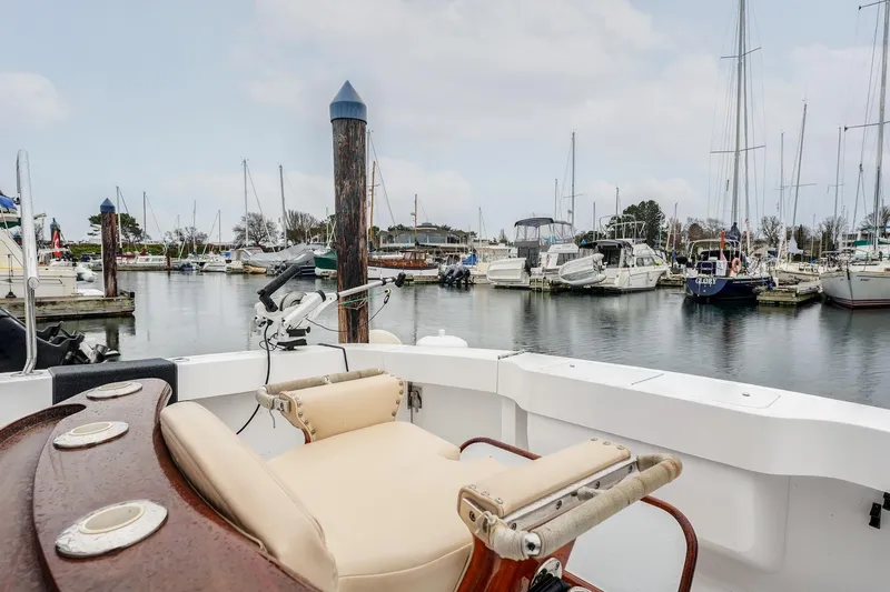 Archangel Yacht Photos Pics 1992 Viking 43 Open boat in marina, featuring fishing chair and scenic harbor view.