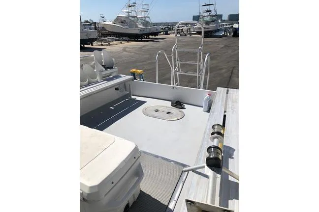  Yacht Photos Pics Newton 31 Dive Special 2014 boat deck with ladder and seating, docked at marina.