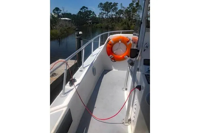  Yacht Photos Pics 2014 Newton 31 Dive Special boat deck with lifebuoy, docked by a serene waterway.
