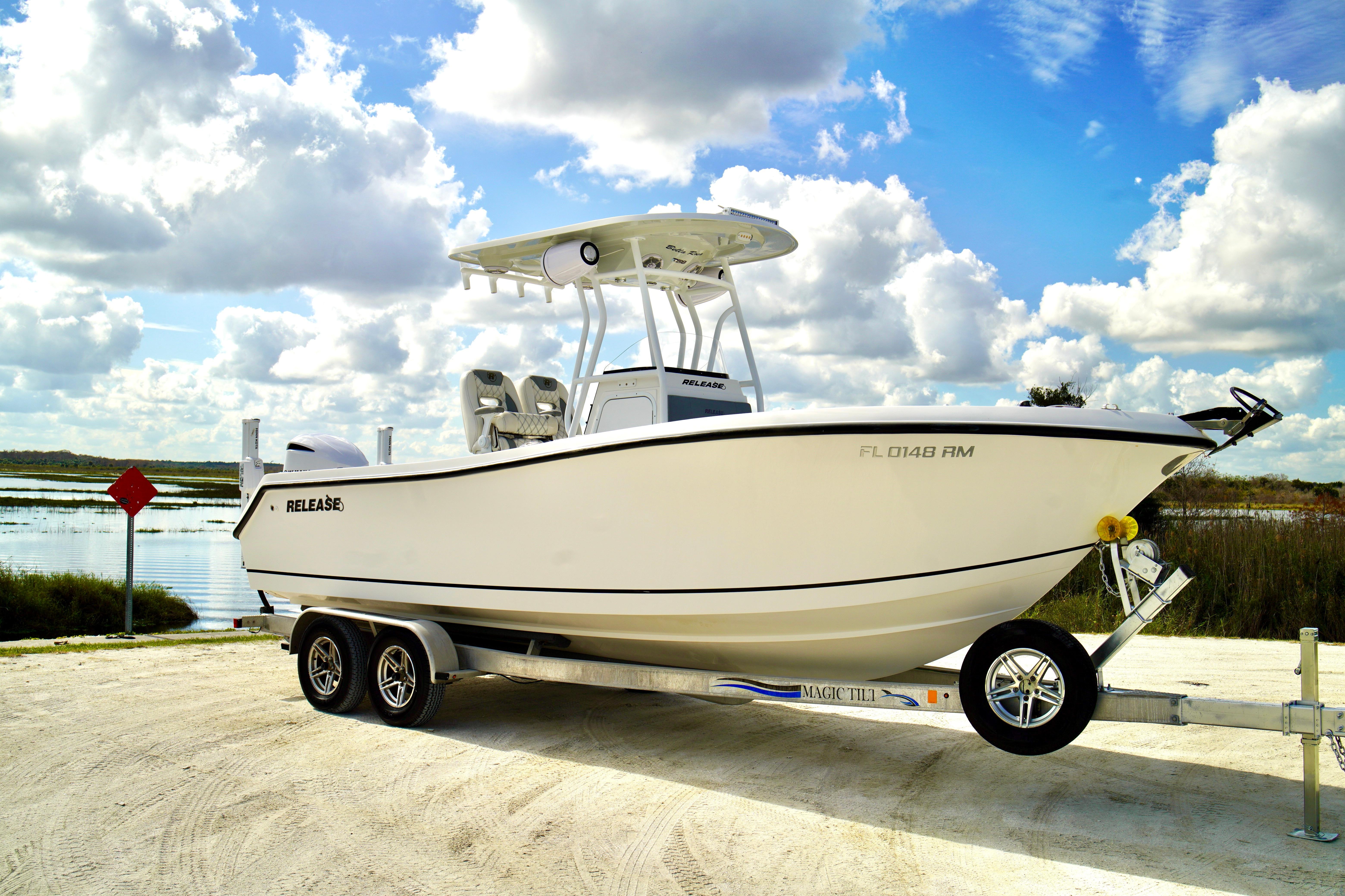 2017 Release 240 RX boat on trailer by a scenic lake under cloudy sky.