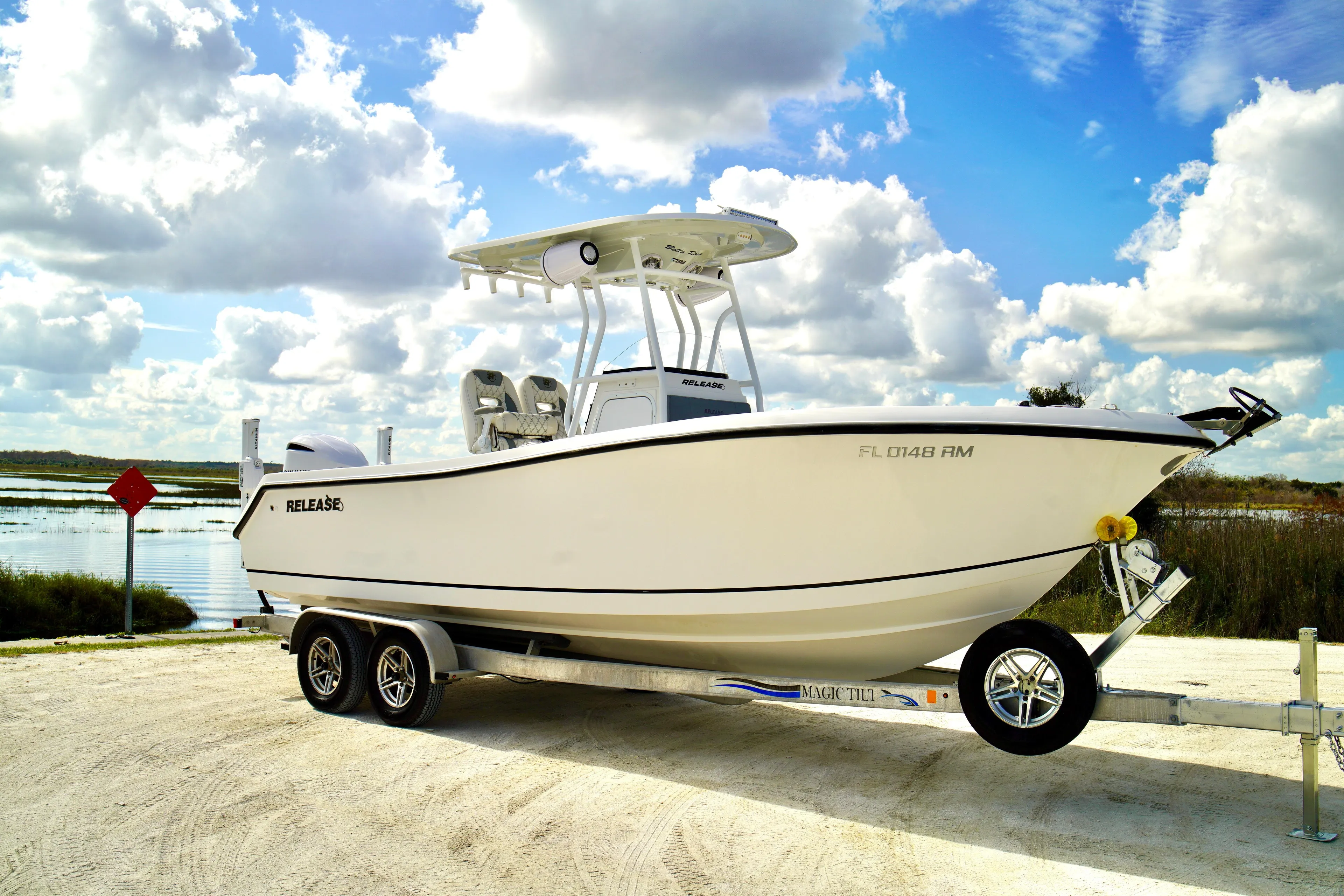 2017 Release 240 RX boat on trailer by a scenic lake under cloudy sky.