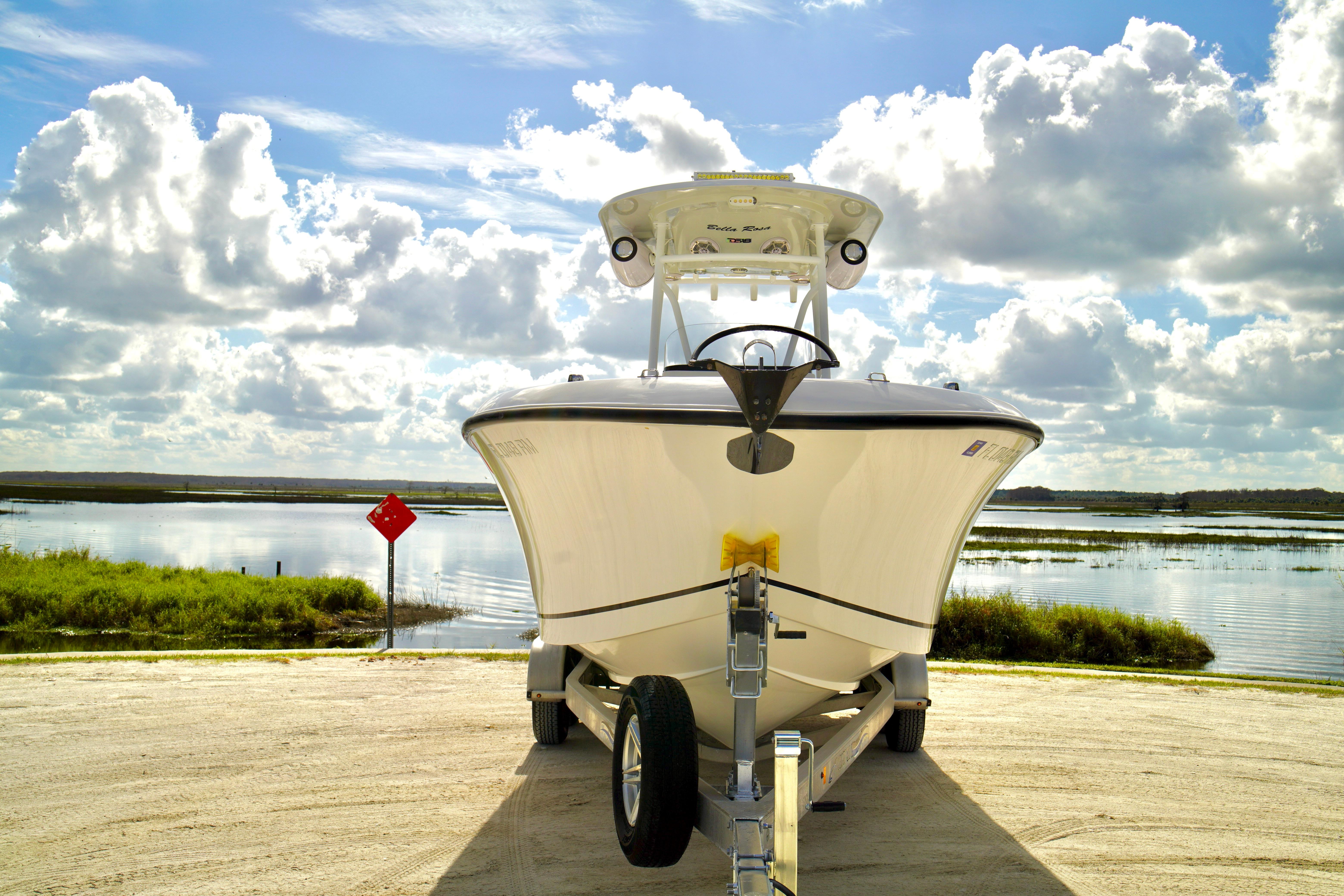 2017 Release 240 RX boat on trailer by scenic lake under cloudy sky.