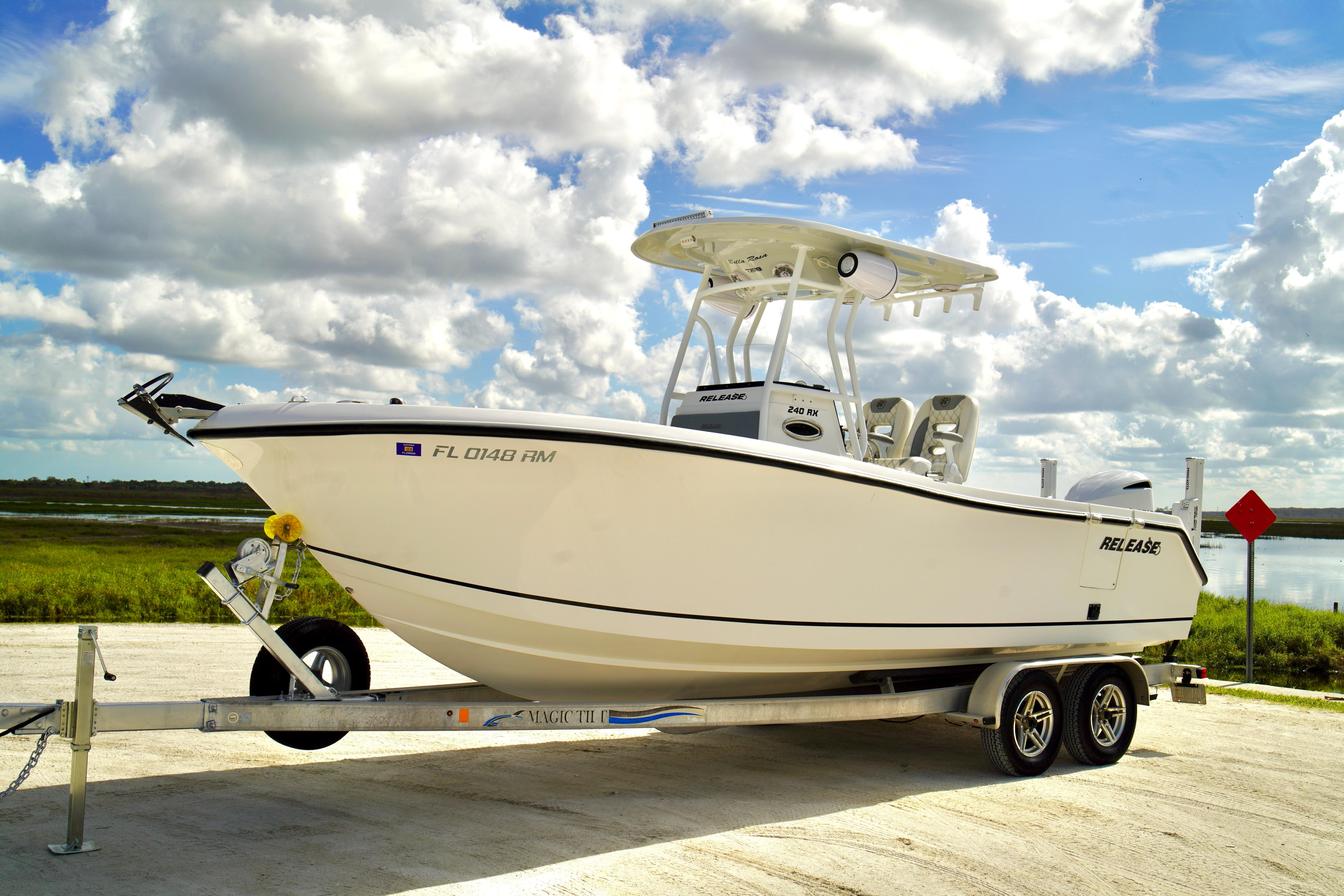 2017 Release 240 RX boat on trailer under cloudy sky, parked near water.