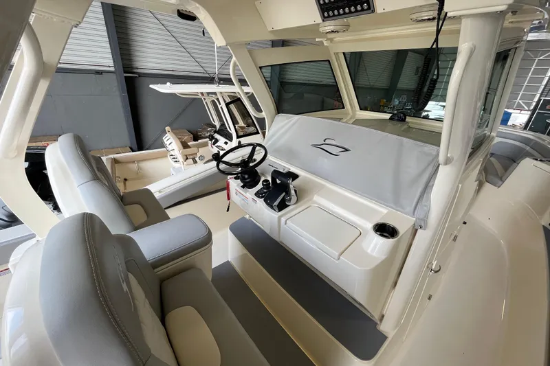 Zippy Yacht Photos Pics 2026 Scout 330 LXF boat interior with helm and seating in a showroom.